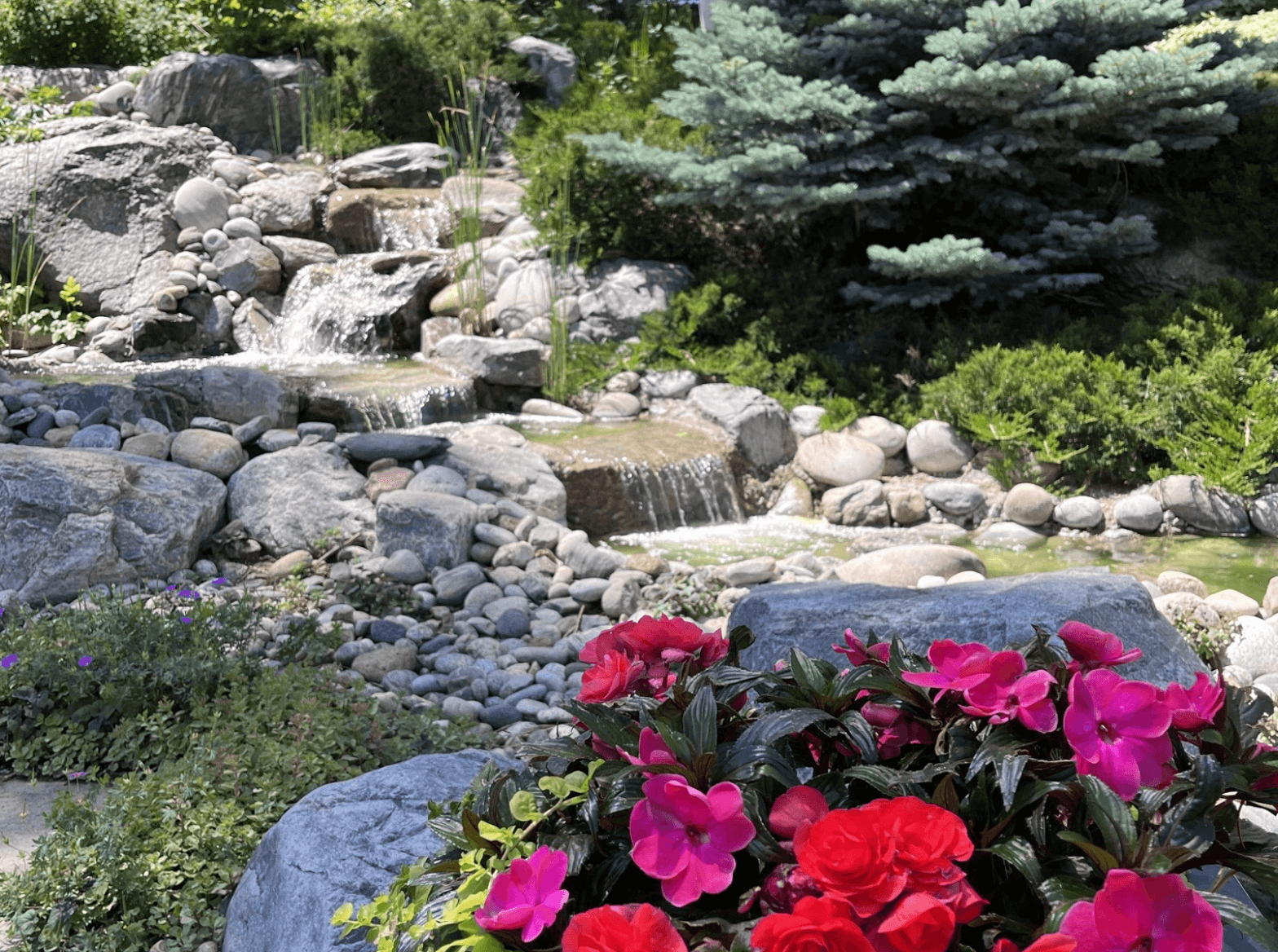 Premium stone patio installation with seating walls and landscape lighting